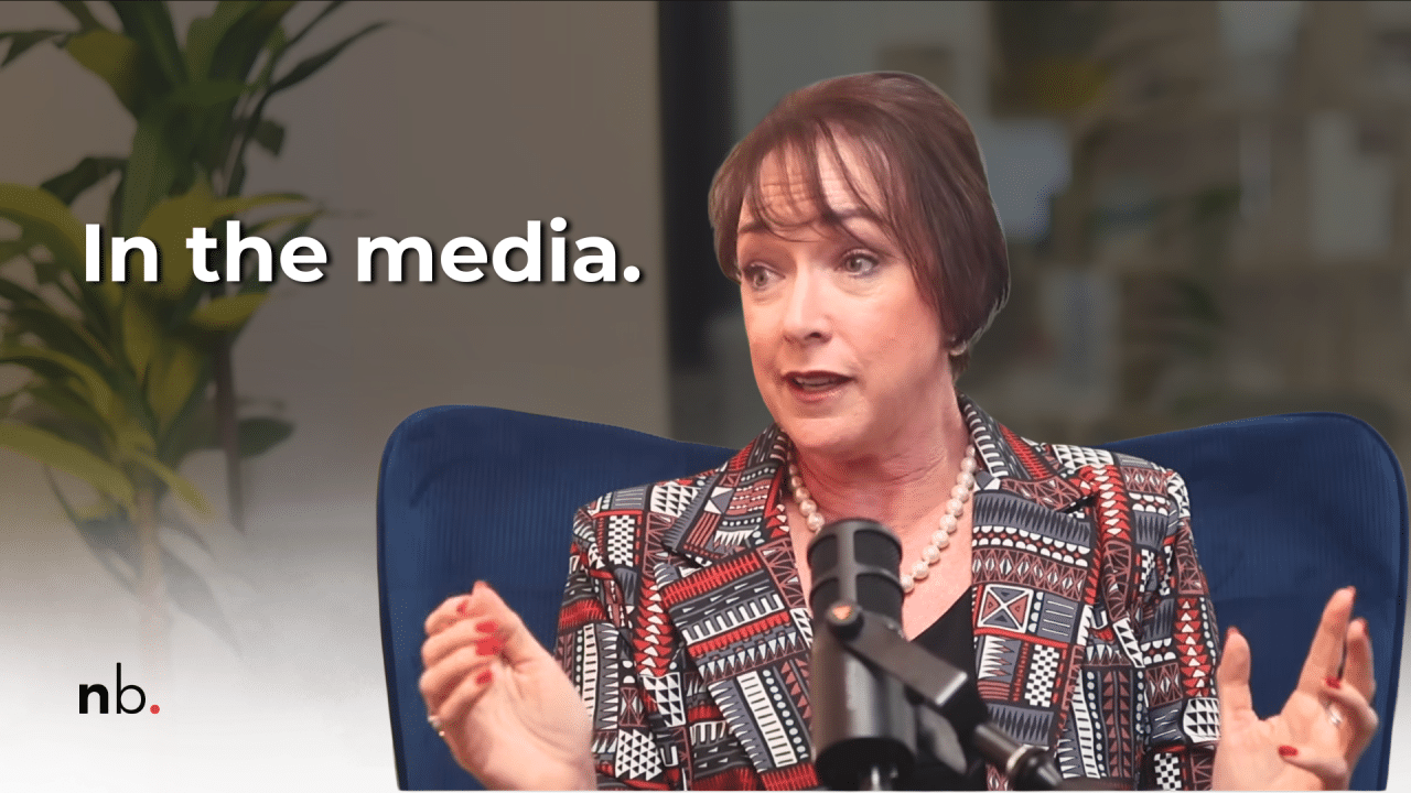 Media soundbites for you _Nikki Bush Nikki Bush speaks into a studio microphone while seated in a blue chair, gesturing with both hands. White text reads “In the media.” and the Nikki Bush “nb.” logo appears in the bottom-left corner.